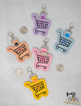 Colorful shopping cart keychains on a textured surface with coins.